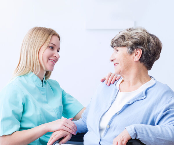 Carer and woman sat in a wheelchair looking at each other