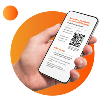 a hand holding a smartphone with EntrySign pre-booked visitor confirmation email displaying details of visit