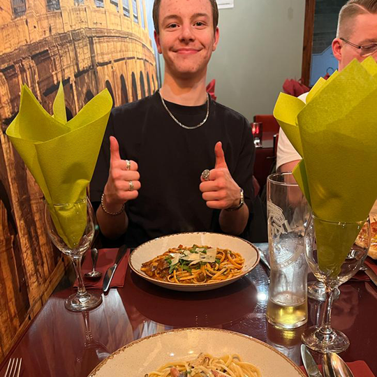 George giving a thumbs up infront of a bowl of pasta