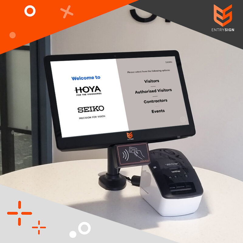 Visitor management screen with grey and white user interface and label printed, fitted to a white desk