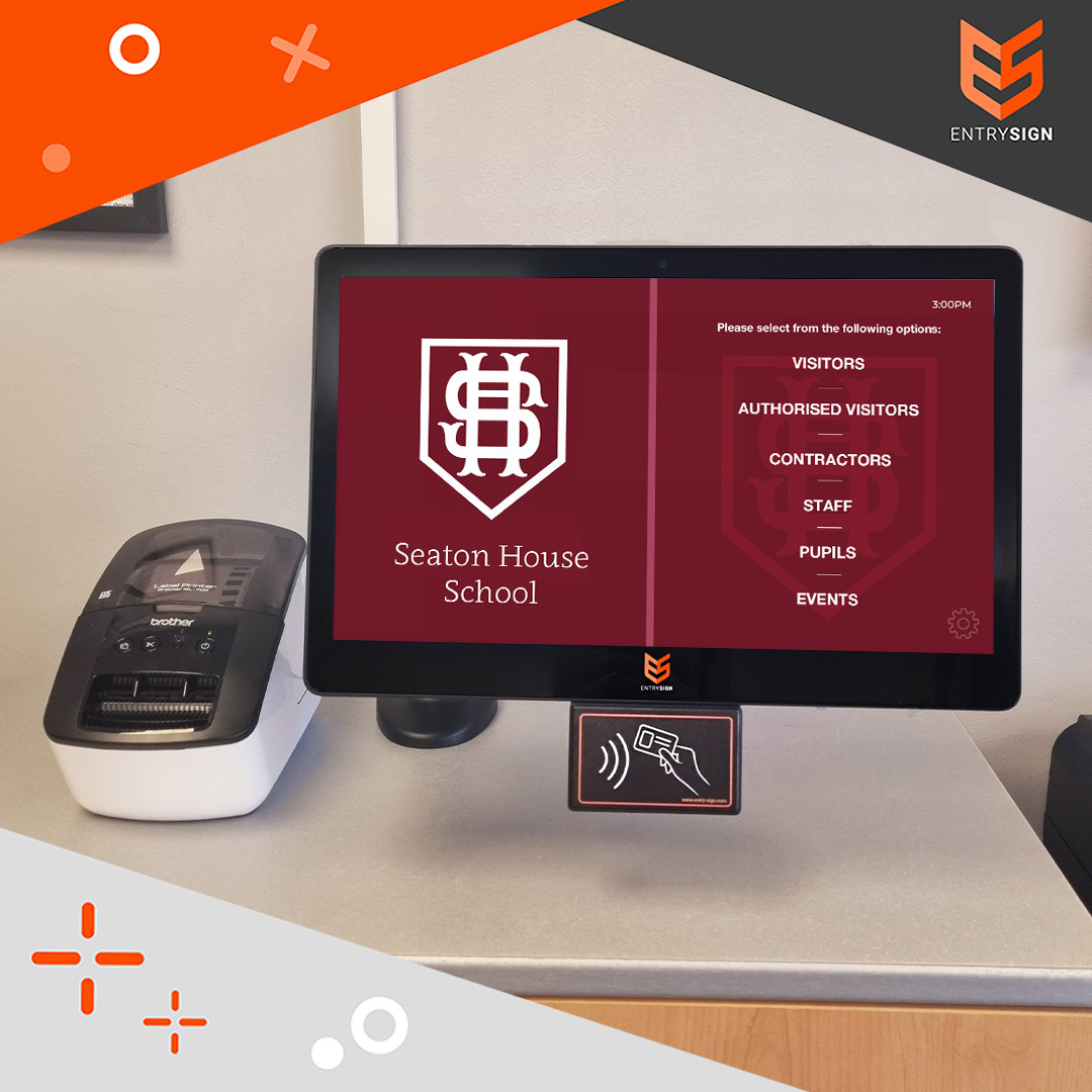 School visitor management screen with red user interface and label printer to the side.